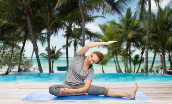 Mujer feliz haciendo yoga y estirando en la estera — Foto de Stock