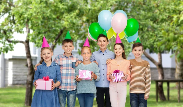 De gelukkige kinderen met geschenken op de verjaardagspartij — Stockfoto