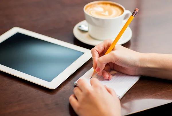 Nahaufnahme einer Frau, die mit Bleistift an ein Notizbuch schreibt — Stockfoto