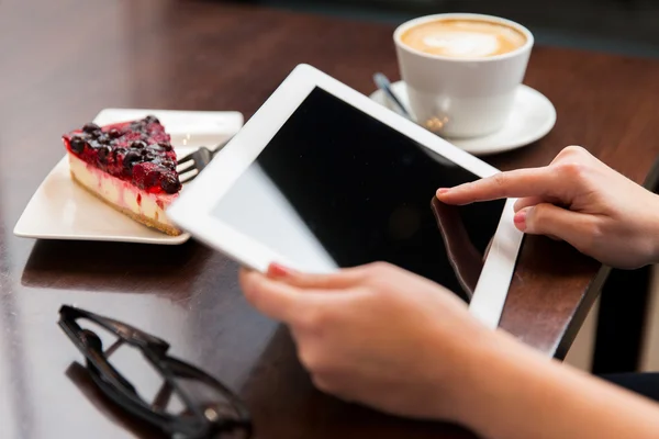 Close up de mãos com tablet pc, café e bolo — Fotografia de Stock