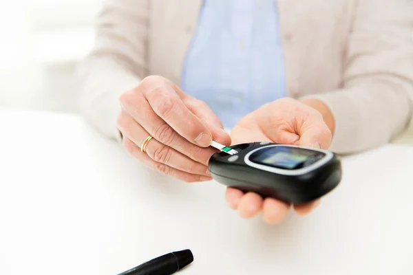 Äldre kvinna med Glukometer kontrollera blodsocker — Stockfoto