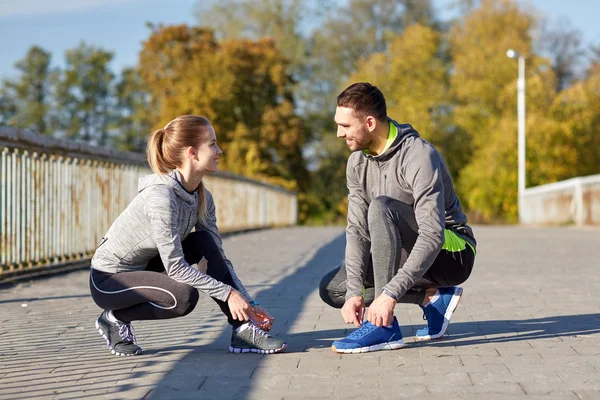 Sonriente pareja atando cordones al aire libre —  Fotos de Stock