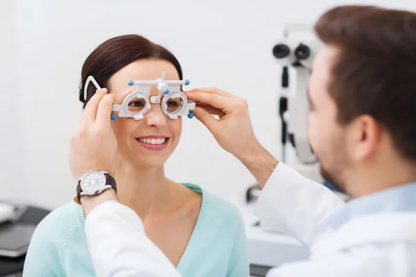 Optician with trial frame and patient at clinic — Stock Photo, Image