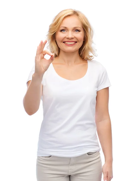 Lycklig kvinna i vit t-shirt visar ok hand tecken — Stockfoto