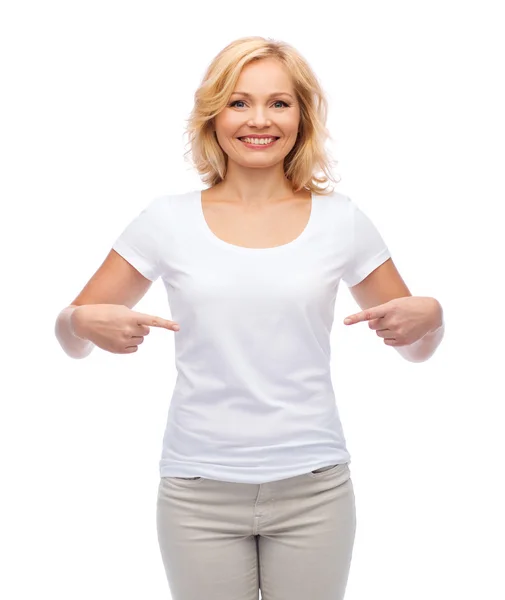 Mujer sonriente con camiseta blanca apuntándose a sí misma — Foto de Stock