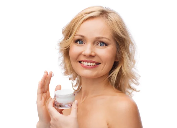 Donna felice applicando crema al suo viso — Foto Stock