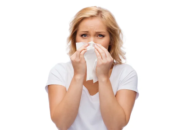 Unhappy woman with paper napkin blowing nose — Stock Photo, Image