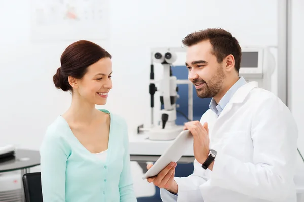 Optician with tablet pc and patient at eye clinic — Stock Photo, Image