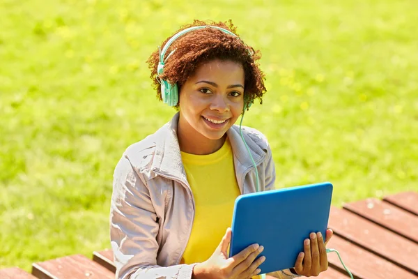 Glückliche Afrikanerin mit Tablet-PC und Kopfhörer — Stockfoto