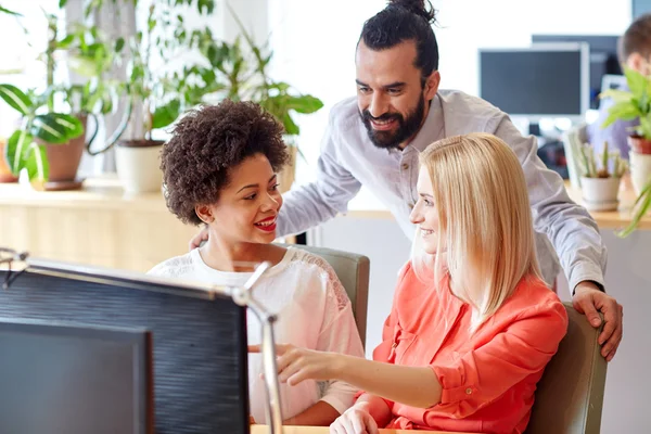 Lykkelig kreativ gruppe med datamaskin i embetet – stockfoto