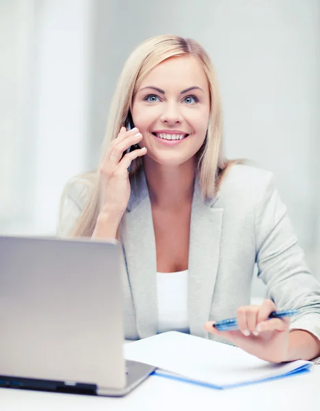 Mujer de negocios con portátil y teléfono celular — Foto de Stock