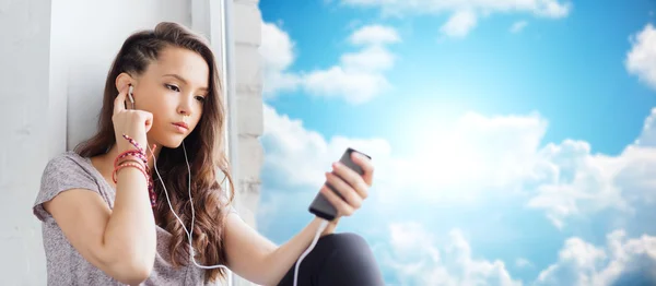 Teenage girl with smartphone and earphones — Stock Photo, Image