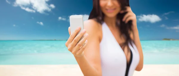 해변에서 스마트폰으로 셀카를 찍고 있는 젊은 여자 — 스톡 사진
