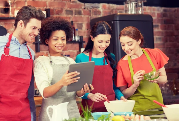 Amigos felices con la tableta de cocina PC en la cocina —  Fotos de Stock
