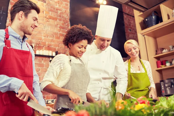 Amis heureux et chef cuisinier cuisine dans la cuisine — Photo