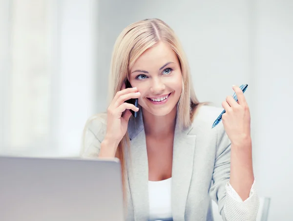 Businesswoman with laptop and cell phone — Stock Photo, Image