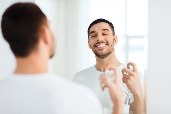 Uomo con profumo cercando di specchio in bagno — Foto Stock