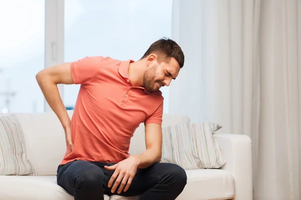 Unglücklicher Mann leidet zu Hause unter Rückenschmerzen — Stockfoto