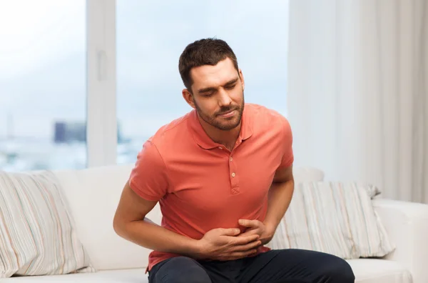 Infeliz homem que sofre de dor de barriga em casa — Fotografia de Stock