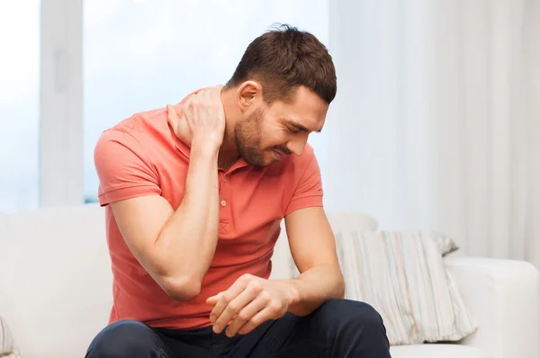 Homem infeliz sofrendo de dor no pescoço em casa — Fotografia de Stock