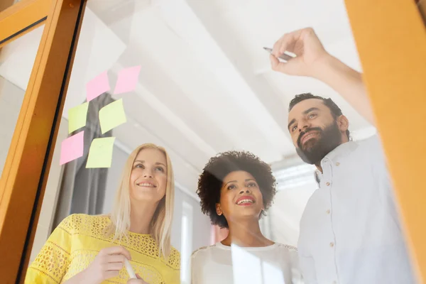 Glückliches Kreativ-Team schreibt auf Aufkleber im Büro — Stockfoto