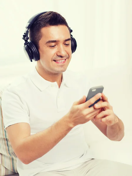 Hombre feliz con teléfono inteligente y auriculares — Foto de Stock