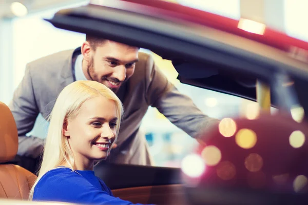 Casal feliz comprar carro em auto show ou salão — Fotografia de Stock