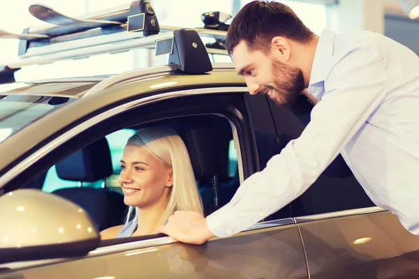 Casal feliz comprar carro em auto show ou salão — Fotografia de Stock