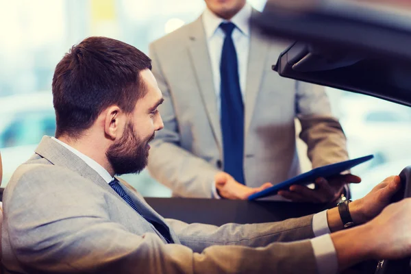 Homem feliz com negociante de carro em auto show ou salão de beleza — Fotografia de Stock