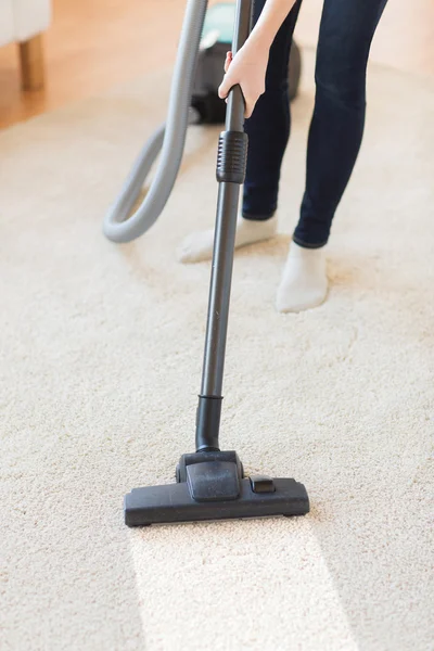 Close up of woman legs with vacuum cleaner at home — Stock Photo, Image