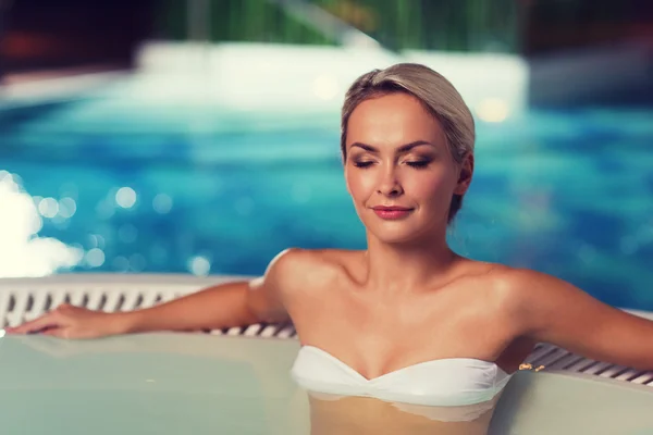 Feliz womani sentado en jacuzzi en piscina — Foto de Stock