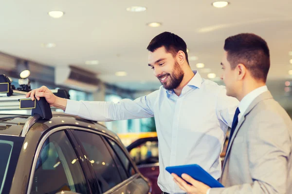 Glücklicher Mann mit Autohändler in Auto-Show oder Salon — Stockfoto