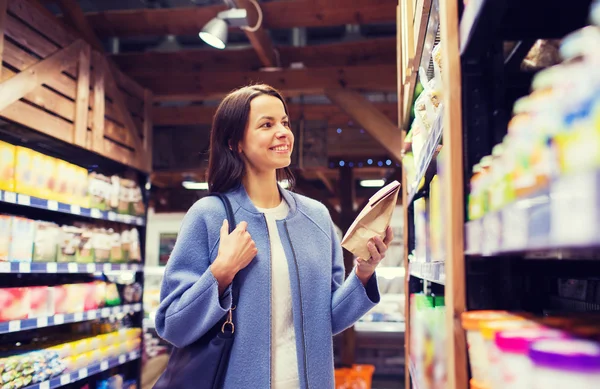 Mulher feliz escolhendo e comprando alimentos no mercado — Fotografia de Stock