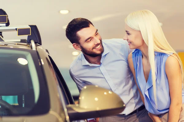 Feliz pareja comprando coche en auto show o salón —  Fotos de Stock