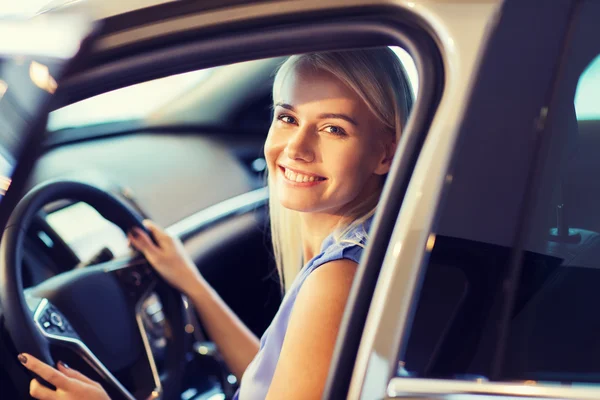 Mulher feliz dentro do carro no auto show ou salão — Fotografia de Stock