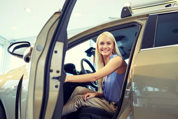 Mujer feliz dentro del coche en auto show o salón — Foto de Stock