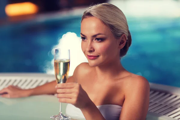 Mulher feliz bebendo champanhe na piscina — Fotografia de Stock