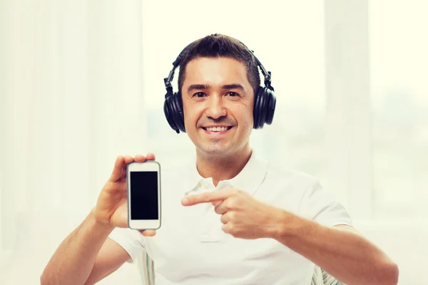 Hombre feliz con teléfono inteligente y auriculares — Foto de Stock