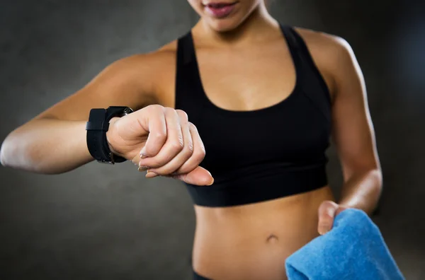 Primer plano de la mujer con smartwatch y toalla en el gimnasio — Foto de Stock