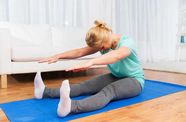 Frau trainiert zu Hause auf Matte — Stockfoto