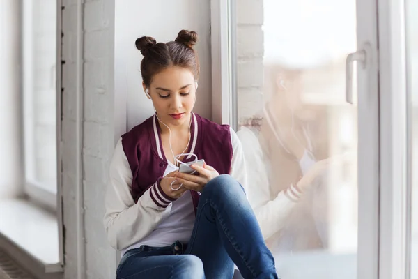 Menina adolescente com smartphone e fones de ouvido — Fotografia de Stock