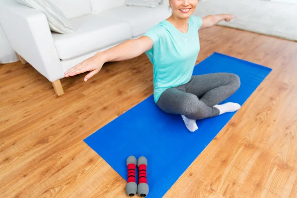 Nahaufnahme einer Frau, die zu Hause auf einer Matte trainiert — Stockfoto