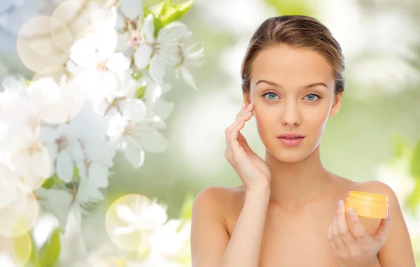 Young woman applying cream to her face Stock Picture