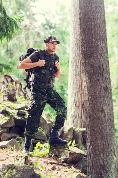 Young soldier with backpack in forest — Stock Photo, Image