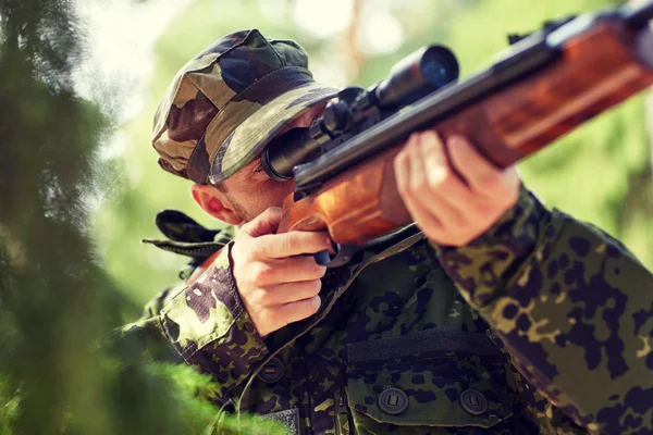 Soldado ou caçador atirando com arma na floresta — Fotografia de Stock