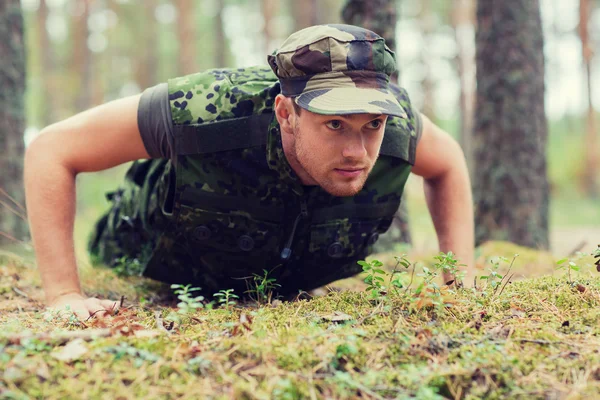 Молодой солдат или рейнджер делает отжимания в лесу — стоковое фото