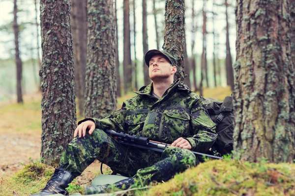 Soldado o cazador con pistola durmiendo en el bosque — Foto de Stock