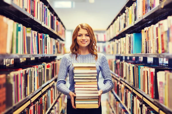 Chica estudiante feliz o mujer con libros en la biblioteca —  Fotos de Stock