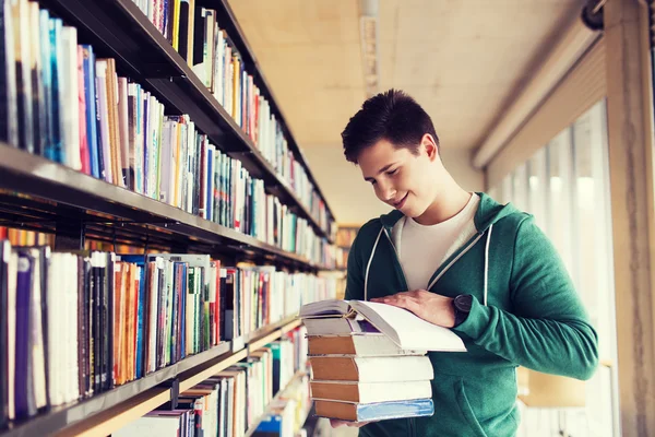 Happy student nebo muž s knihou v knihovně — Stock fotografie