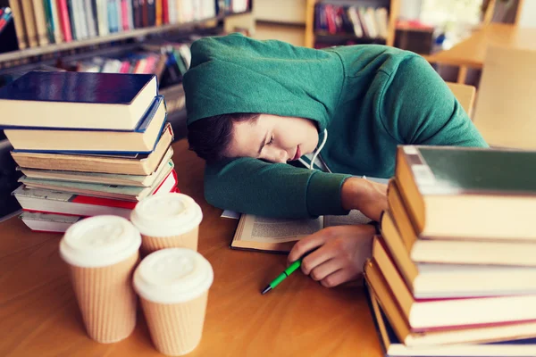 Уставший студент или человек с книгами в библиотеке — стоковое фото